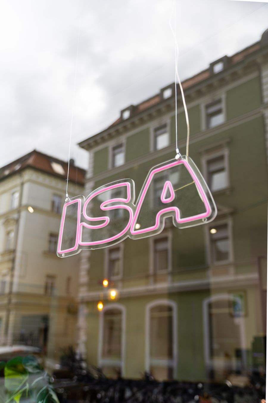 Pinkes ISA-Neonschild im Schaufenster des Studios